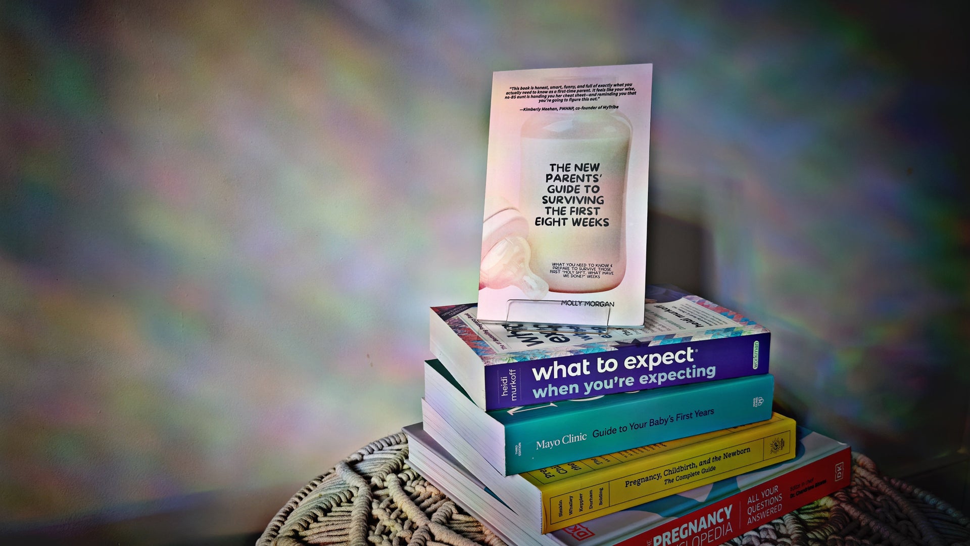 Stack of books on a textured surface with a colorful, blurred background